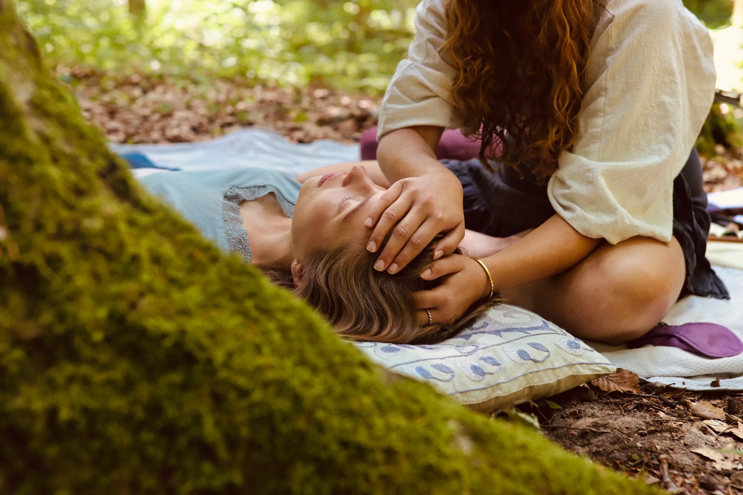 Breathwork-Session im Wald: Anna legt einer liegenden Person die Hände auf