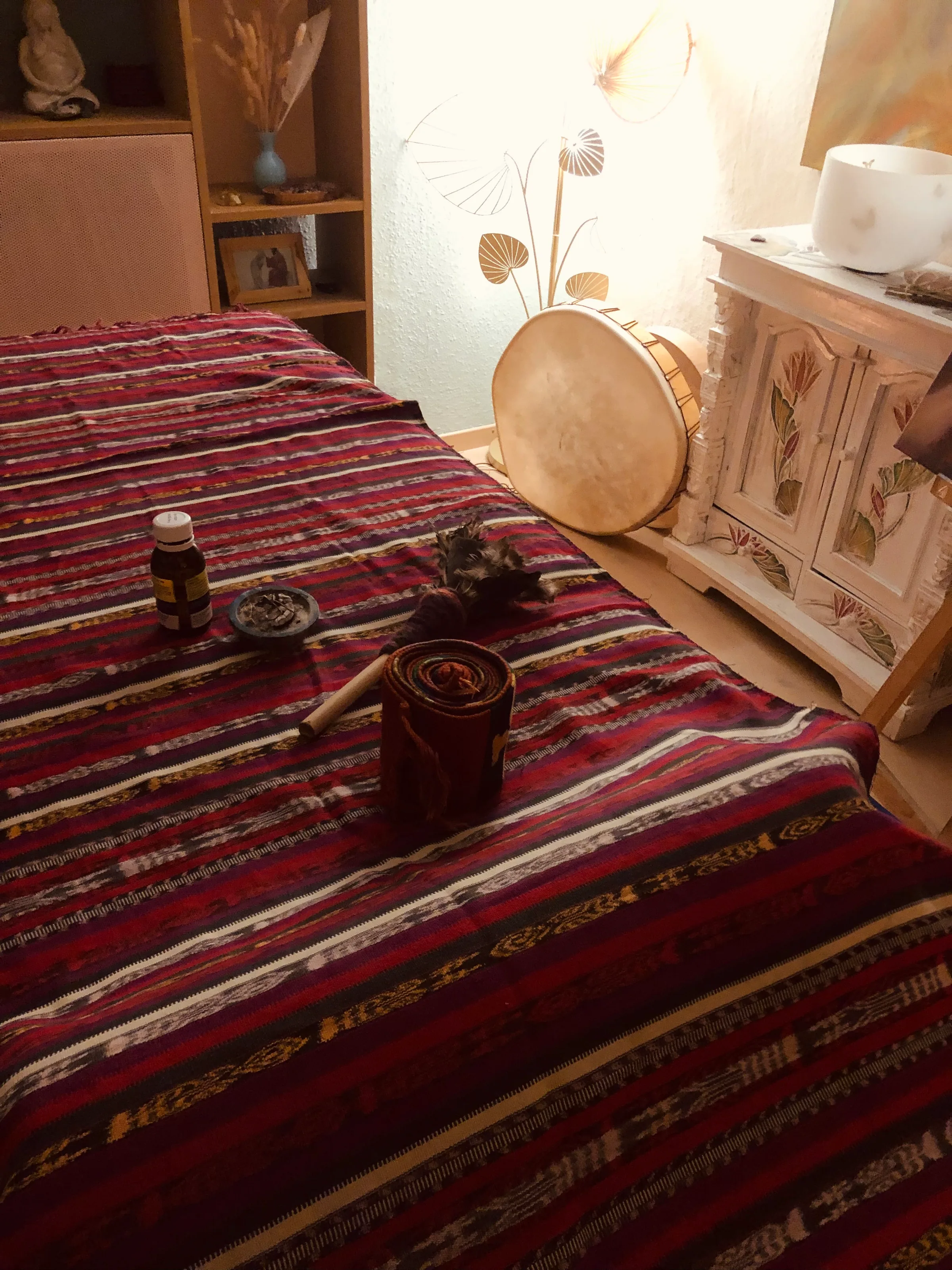 Annas Behandlungsraum mit rotem Maya-Textil und Kerzen